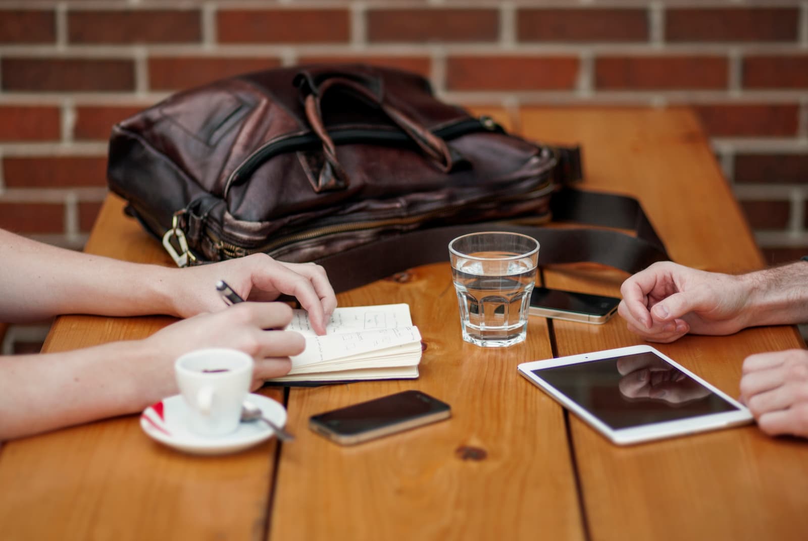 A client conversation across a table with notes and a tablet