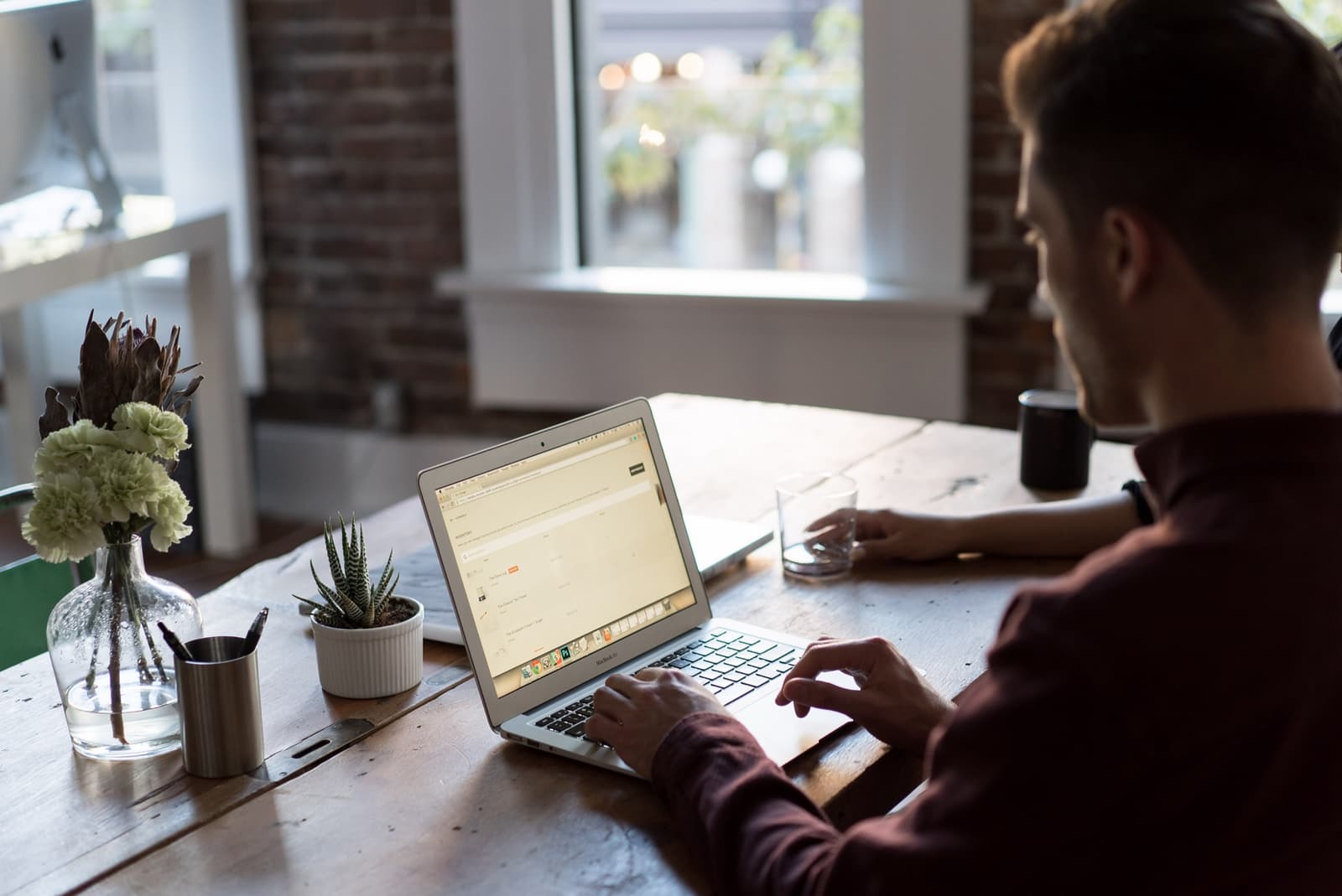 An IT specialist working through a support queue at a laptop