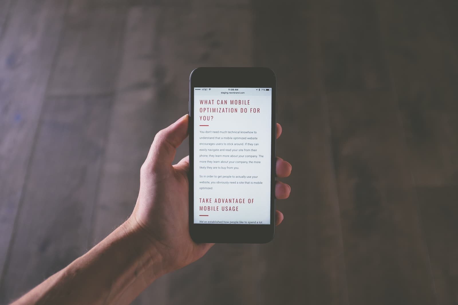 A website viewed on a phone held in one hand